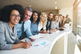 Equipe de trabalho olhando para a câmera e analisando os fatores de empregabilidade