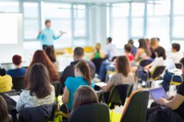 Uma sala com diversas pessoas prestando atenção em uma aula na empresa, mostrando ser uma organização que se preocupa com a educação corporativa