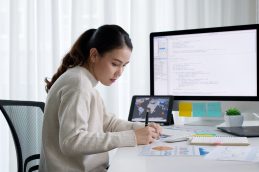 Uma mulher estudando em frente ao computador, fazendo uma especialização para começar o ano de 2024 bem, profissionalmente falando