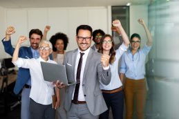 Sete pessoas juntas em um ambiente empresarial, representando a gestão tributária e o sucesso empresarial